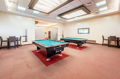 a room with two pool tables and chairs at Redesigned High-Rise 1BR Near Key Landmarks, Elite Residence, Dubai Marina by Deluxe Holiday Homes in Dubai