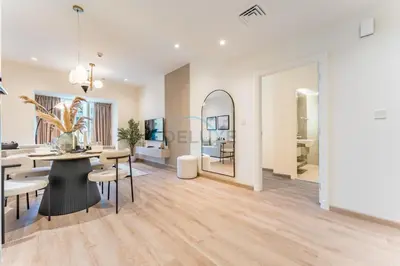 a dining room and living room with a table and chairs at Redesigned High-Rise 1BR Near Key Landmarks, Elite Residence, Dubai Marina by Deluxe Holiday Homes in Dubai