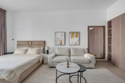 a bedroom with a bed and a couch and a table at Luxury new studio Dubai Marina 10min to the beach in Dubai