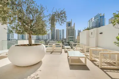 a large white pot with a tree on top of a building at Luxury new studio Dubai Marina 10min to the beach in Dubai
