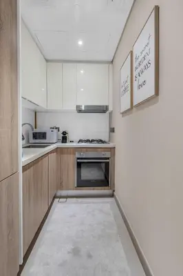 a kitchen with white cabinets and a stove at Luxury new studio Dubai Marina 10min to the beach in Dubai
