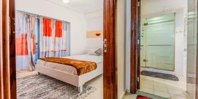 a small bedroom with a bed and a shower at 1 BR Spacious Apartment - JLT in Dubai
