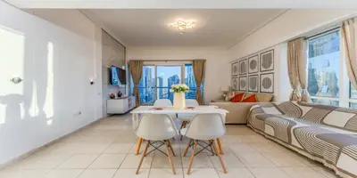 a living room with a table and chairs and a couch at 1 BR Spacious Apartment - JLT in Dubai