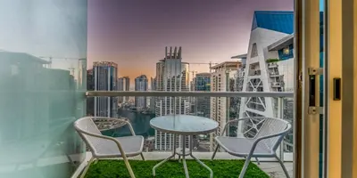 a balcony with a table and chairs and a view of the city at 1 BR Spacious Apartment - JLT in Dubai