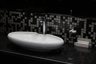 a white sink on a black counter in a bathroom at Bay's Edge, Luxury Canal View 2BR in Business Bay in Dubai