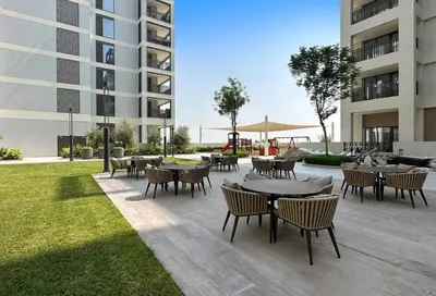 a patio with tables and chairs in front of a building at Spacious 3BR, Private Beach Access in Dubai