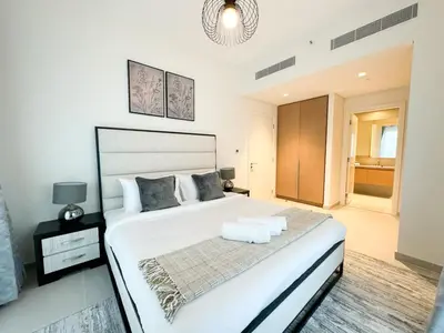 a bedroom with a large white bed with two towels at Spacious 3BR, Private Beach Access in Dubai