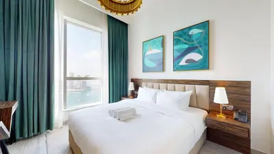 a bedroom with a large white bed and a window at Locations I Avani Palm View I Luxury 2 Bedroom I Sea View I Pool, Gym, Parking, Wi-Fi in Dubai