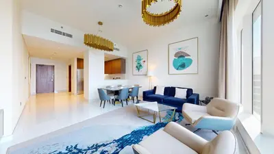 a living room with a blue couch and a table at Locations I Avani Palm View I Luxury 2 Bedroom I Sea View I Pool, Gym, Parking, Wi-Fi in Dubai