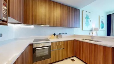 a kitchen with wooden cabinets and a stove and a sink at Locations I Avani Palm View I Luxury 2 Bedroom I Sea View I Pool, Gym, Parking, Wi-Fi in Dubai