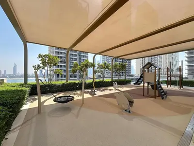 a view of a playground in a building with a city at Grand Bleu - Luxurious One Bedroom with Sea View in Dubai