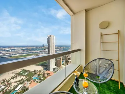 a balcony with two chairs and a view of the city at Palm & Sea View Beach Acess JBR walk Skydive clubs in Dubai