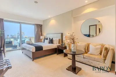 a bedroom with a bed and a couch and a mirror at The Chic in Dubai