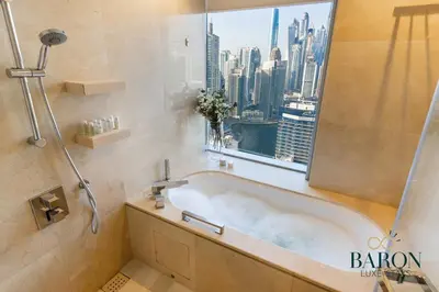 a bathroom with a bath tub with a window at The Chic in Dubai