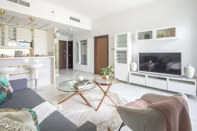 a living room with a couch and a tv at Frank Porter - Botanica Tower in Dubai