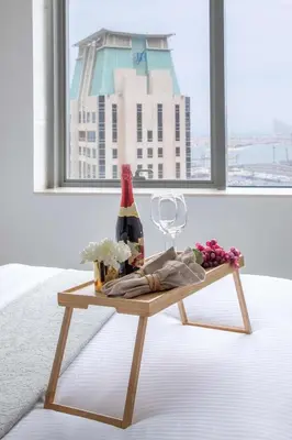 a table with a bottle of wine and a glass at Frank Porter - Botanica Tower in Dubai