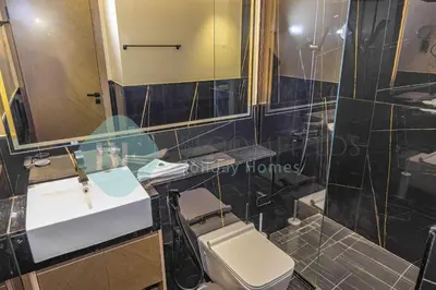 a bathroom with a sink and a toilet and a mirror at Bloomfields Stylish 1Br In Binghatti Creek Jaddaf in Dubai
