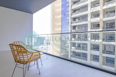 a balcony with two chairs and a large window at Bloomfields Stylish 1Br In Binghatti Creek Jaddaf in Dubai