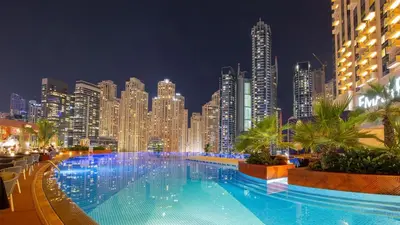 a large pool in front of a city at night at Address Dubai Marina, Dubai Marina - Mint Stay in Dubai