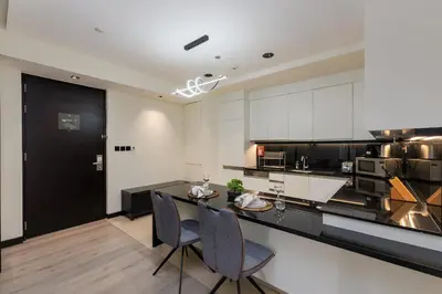 a kitchen with white cabinets and a black counter top at Address Dubai Marina, Dubai Marina - Mint Stay in Dubai