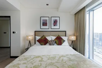 a bedroom with a large white bed with two lamps at Address Dubai Marina, Dubai Marina - Mint Stay in Dubai