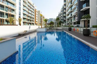 a large swimming pool in the middle of a building at Fully Furnished Modern Studio Apartment Nearby Meydan Racecourse in Dubai