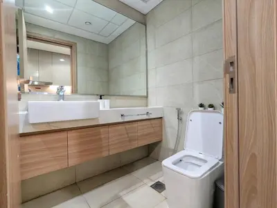 a bathroom with a toilet and a sink and a mirror at Fully Furnished Modern Studio Apartment Nearby Meydan Racecourse in Dubai