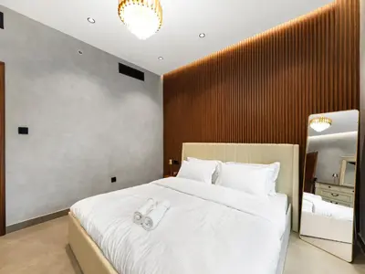 a bedroom with a large white bed with slippers on it at Luxury Apartment In the Heart of Dubai Marina in Dubai
