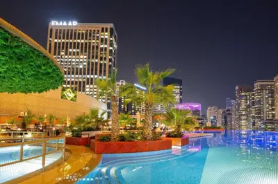 a large swimming pool with a city skyline at night at Cosmos Living Studio at JW Marina in Dubai
