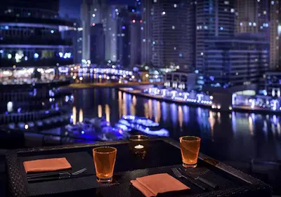 a table with a view of a city at night at Cosmos Living Studio at JW Marina in Dubai