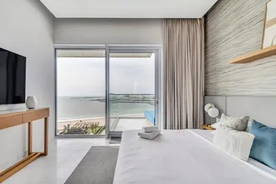 a bedroom with a large bed with a view of the beach at GuestReady - Panoramic views from One JBR in Dubai