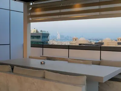 a table and chairs in a room with a view at High End 4BR Penthouse with Private Pool and Skyline Views in Dubai