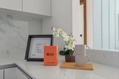 a counter with a book and two mugs and a picture at GuestReady - Modern retreat in JVC in Dubai