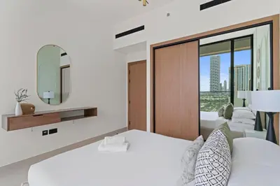 a white bedroom with a large bed and a mirror at GuestReady - Modern retreat in JVC in Dubai