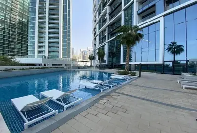 a swimming pool with lounge chairs in a building at High-Floor Luxury 2BR, Sea View, Address JBR in Dubai