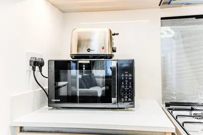 a microwave sitting on top of a kitchen counter at Modern one bedroom apartment in lotus creek beach in Dubai
