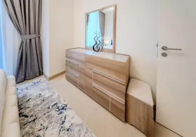 a bedroom with a dresser with a mirror and a drawer at Modern one bedroom apartment in lotus creek beach in Dubai