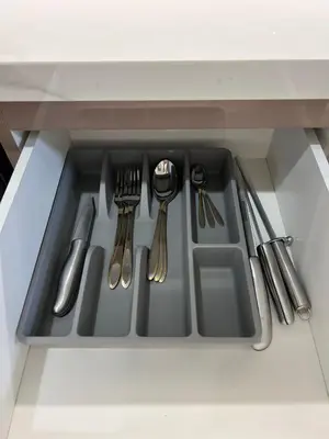 a kitchen sink with silver utensils in a drawer at Azizi riviera in Dubai