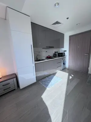 a kitchen with a white refrigerator and a stove at Azizi riviera in Dubai