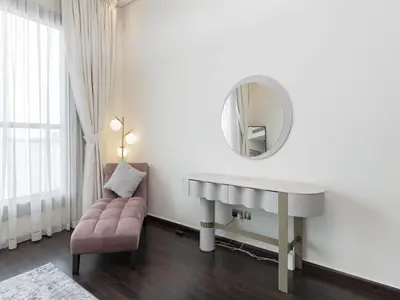 a bathroom with a sink and a mirror and a chair at Dream Palm Residence 3BR Luxury Apartment on Palm Jumeirah in Dubai