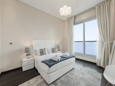a white bedroom with a bed and a large window at Dream Palm Residence 3BR Luxury Apartment on Palm Jumeirah in Dubai