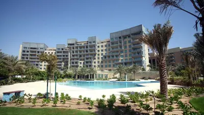 a large apartment building with a swimming pool and palm trees at Dream Palm Residence 3BR Luxury Apartment on Palm Jumeirah in Dubai
