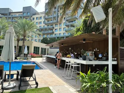 a bar next to a swimming pool next to a building at Dream Palm Residence 3BR Luxury Apartment on Palm Jumeirah in Dubai