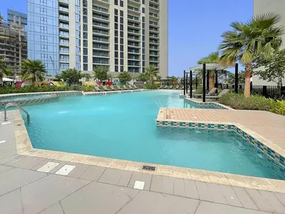 a large swimming pool in a city with buildings at FIRST CLASS 1BR Luxe Comfort Stylish Design in Dubai