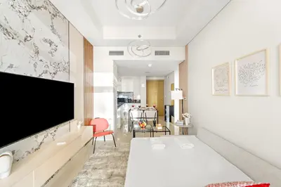 a bedroom with a bed and a flat screen tv at FIRST CLASS 1BR Luxe Comfort Stylish Design in Dubai
