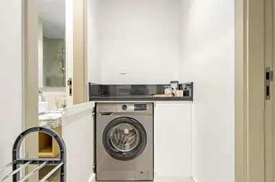 a washer and dryer in a white kitchen at FIRST CLASS 1BR Luxe Comfort Stylish Design in Dubai