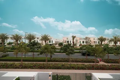 a view of a street with palm trees and buildings at Luxury 4BR Villa, Bali Pool Retreat, Ruba A Ranches 3 in Dubai