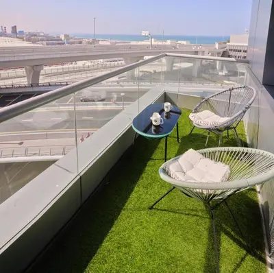 two chairs and a table on a balcony with an airport at Bedroom 5 in Dubai