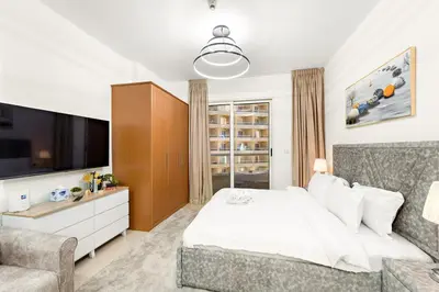 a bedroom with a bed and a tv and a couch at FIRST CLASS Studio Cozy & Chic Retreat in Dubai