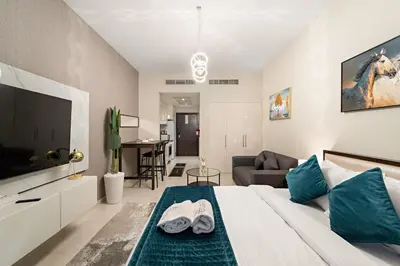 a bedroom with a large bed and a living room at FIRST CLASS Studio Luxe Cozy Living in Dubai